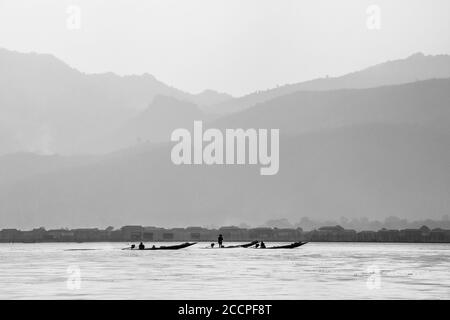 Lo stile di vita nel lago Inle con i suoi famosi pescatori che girovagano le gambe presi in bianco e nero Foto Stock