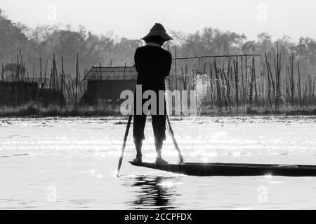 Lo stile di vita nel lago Inle con i suoi famosi pescatori che girovagano le gambe presi in bianco e nero Foto Stock