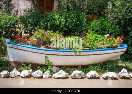 Una vecchia barca a remi riutilizzata come contenitore per le piante, nel villaggio di Kardamyli, nel mani, Peloponneso, Grecia. Foto Stock