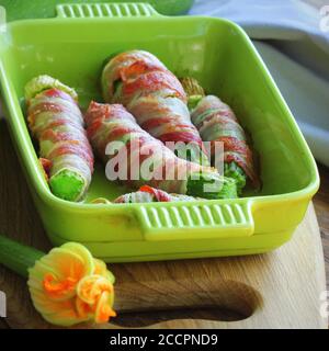 Patatine grigliate di zucchine avvolte in una pancetta in una padella da cucina Foto Stock