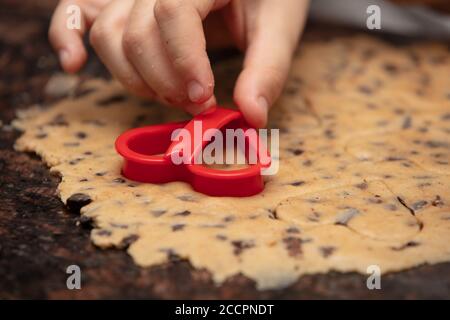 Primo piano bambino`s mani che preparano i biscotti Foto Stock