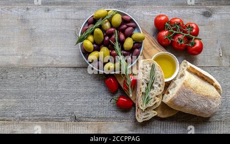 Pane fresco alla ciabatta con olio d'oliva, pomodori ciliegini freschi e olive Foto Stock