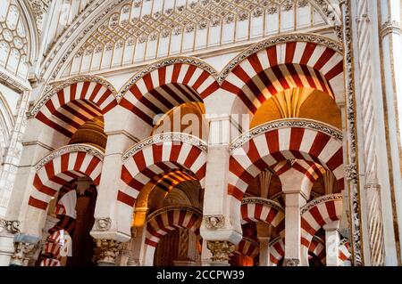 Alternanza di voussoirs di archi doppi presso la grande Moschea di Cordova arco inferiore a ferro di cavallo e arco semicircolare superiore in Spagna. Foto Stock