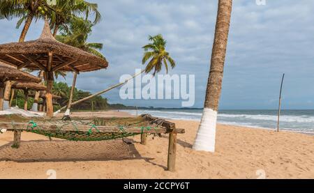 Africa spiaggia tropicale con palme e lettini in piedi vuoto, la spiaggia si trova sulla costa dorata del Ghana Axim Foto Stock