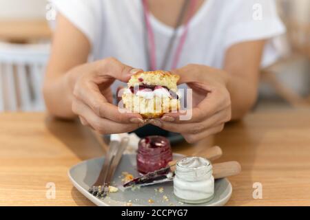 La donna tiene una marmellata di mirtilli spalmata e un cono coagulato. Foto Stock