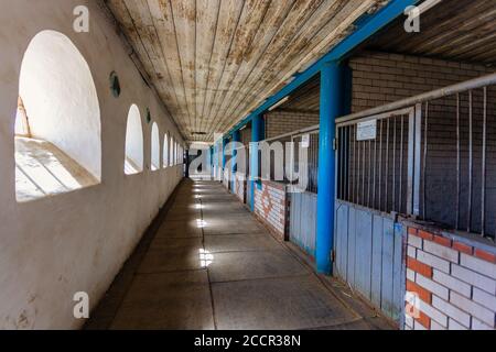 Vecchia scuderia storica con box di cavalli sciolti, vista sul tunnel Foto Stock