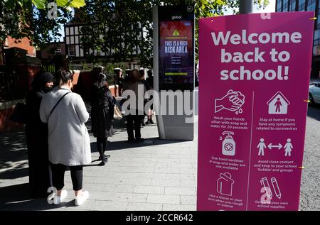 Leicester, Leicestershire, Regno Unito. 24 agosto 2020. Genitori e bambini si accodano per acquistare le loro uniformi scolastiche da un negozio uniforme Direct durante la pandemia del coronavirus. Il primo ministro Boris Johnson dice che Òvitally importantÓ i bambini tornano in classe. Credit Darren Staples/Alamy Live News. Foto Stock