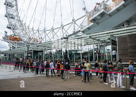 WESTMINSTER LONDRA, Regno Unito - 24 agosto 2020 turisti e turisti che indossano una coda di mascherine protettive per il London Eye che ha riaperto dopo che le restrizioni di blocco del coronavirus sono state attenuate. Credit: amer Ghazzal/Alamy Live News Foto Stock