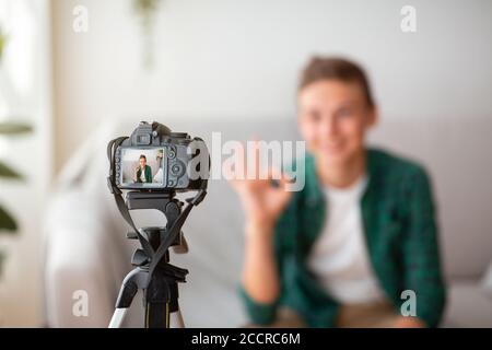 Fuoco selettivo sulla macchina fotografica che spara il ragazzo teen mostrando OK Foto Stock