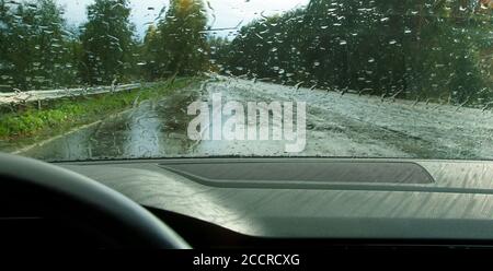 Pioggia sul parabrezza dell'auto, parcheggiata alla fermata di riposo dell'autostrada, a Estate, Finlandia Foto Stock