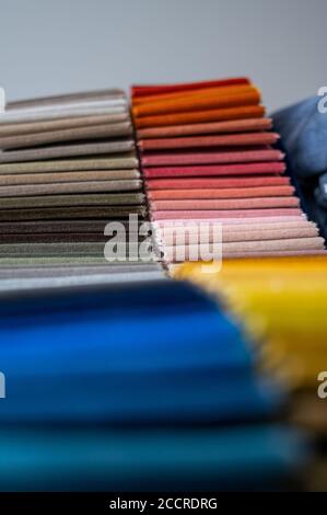 Campioni di velluto di lusso di colore sfumato piegati in file e posizionati in un mucchio su un tavolo Foto Stock