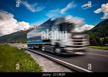 Carrello carburante precipita l'autostrada sullo sfondo delle Alpi. Carrello Car in motion blur. Foto Stock