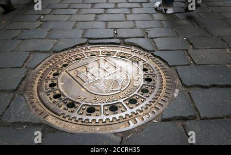 Coperta ornata di tombino, parte della rete fognaria di Praga, (Prazska Kanalizace), stare Mesto (Città Vecchia), Praga. Repubblica Ceca Foto Stock