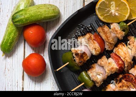 Primo piano di kebab di pollo su una padella nera Foto Stock