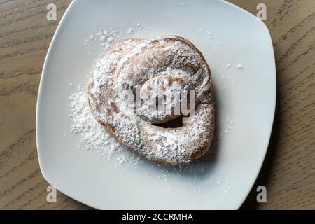 Primo piano ad angolo di un dessert spagnolo Ensaimada con zucchero a velo Foto Stock