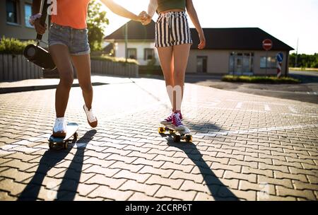 Ragazze adolescenti irriconoscibili amici con skateboard all'aperto in città. Foto Stock