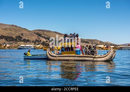 Puno, Perù - 9 ottobre 2015: Turisti sulla barca a canna, isole galleggianti Uros del lago Titicaca, Perù, Sud America Foto Stock