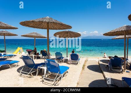 Lettini e ombrelloni presso la spiaggia di Kloni Gouli vicino a Gaios, Paxos, Isole IONIE, Grecia Foto Stock