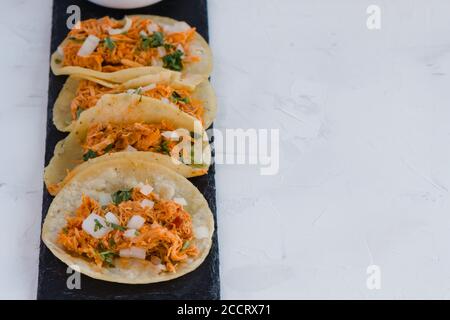 Tacos dal Messico sulla sinistra pieno di tinga de pollo, tradizionale da Nayarit. Spazio di copia a destra Foto Stock