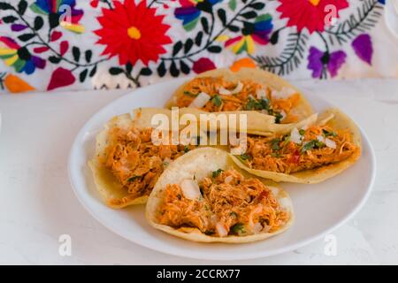 Tacos tradizionali con tinga de pollo su tovaglia ricamata Messico Foto Stock