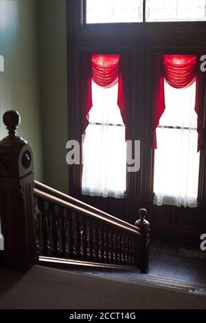 Una scalinata e finestre all'interno del museo Flavel House di Astoria, Oregon, USA. Foto Stock