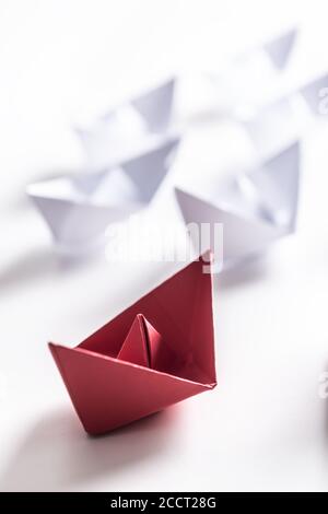 Barche di carta rossa e bianca. Concetto di barche di leadership per il gruppo di lavoro di squadra o il successo Foto Stock