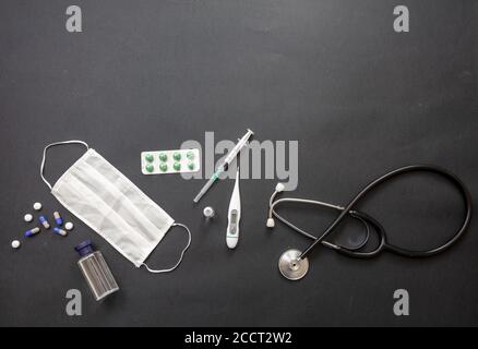 Apparecchiature mediche di protezione del coronavirus. Maschera protettiva, vaccino, COVID 19, materiale medico per la diagnosi e la prevenzione e strumenti su sfondo nero, Foto Stock