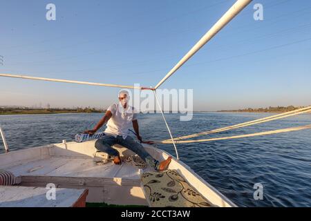 Uomo che si rilassa sulla feluca sul Nilo, Luxor, Egitto Foto Stock