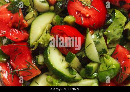 Insalata di verdure con cetrioli e pomodori come sfondo Foto Stock