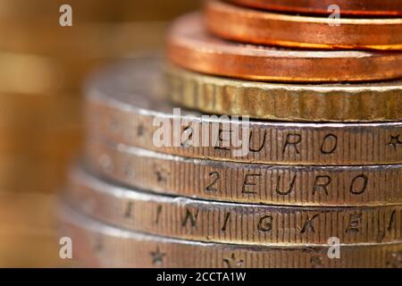 Vista ravvicinata su una pila di monete in euro. "2 euro" inciso sul lato di due monete Foto Stock