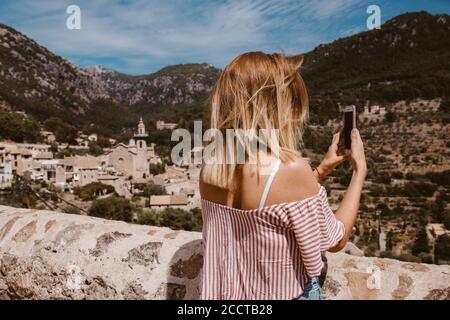 Donna in viaggio scattando una foto con il telefono di Il paesaggio di Maiorca Foto Stock