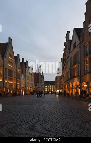 Muenster, Prinzipalmarkt al crepuscolo, ora blu, case illuminate a timpano, via dello shopping di lusso, vista sull'antica strada acciottolata, Germania, Europa. Foto Stock