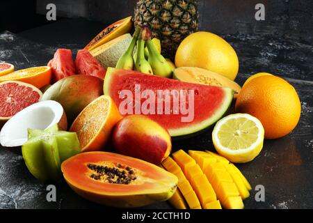 Frutti tropicali sfondo, molti frutti tropicali maturi colorati su tavolo rustico Foto Stock