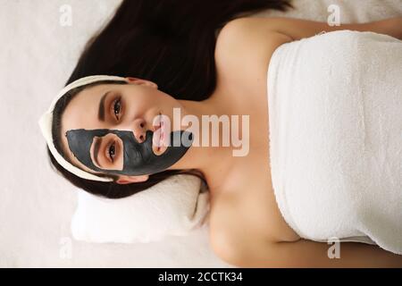 Maschera cosmetica sul viso, brunette che fa trattamenti presso il centro termale Foto Stock