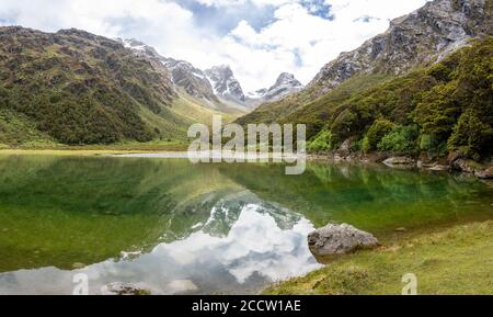 Riflessione di Emily Peak nel Lago Mackenzie al famoso Routeburn Track, Fjordland National Park, Southland / Nuova Zelanda Foto Stock