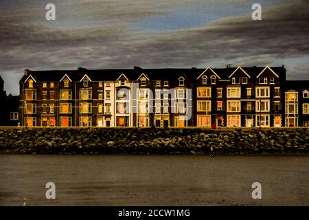 Morecambe, Lancashire, Regno Unito. 24 agosto 2020. Casa a schiera su Sandyland beeing illuminata dal postbagliore dal setting su, Credit: PN News/Alamy Live News Foto Stock