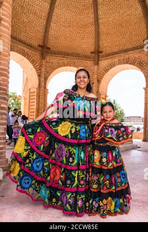 Una giovane donna e una ragazza nel tipico costume da ballo di Chiapa de Corzo posano nella fontana la pila. Chiapas, Messico. Foto Stock