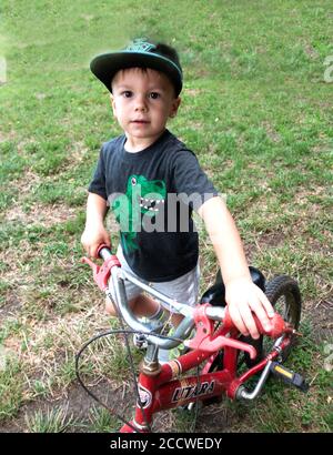 Un bambino polacco sportivo che pratica la sua moto a piede. Zawady Gmina Rzeczyca Polonia Foto Stock