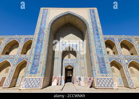 Iwan di Ulugh Beg Madrasah a Bukhara, Uzbekistan. Portale d'ingresso di madrassah decorato con maioliche in pishtaq e piastrelle di ceramica blu. Foto Stock