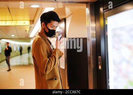 L'uomo asiatico invia un record vocale per chiedere la direzione e la ricerca la stazione della metropolitana sulla mappa Foto Stock