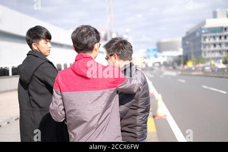 Giovani amici asiatici viaggiano insieme in città e fotografo imposta l'abito e l'azione del modello per il concetto di scatto fotografico Foto Stock