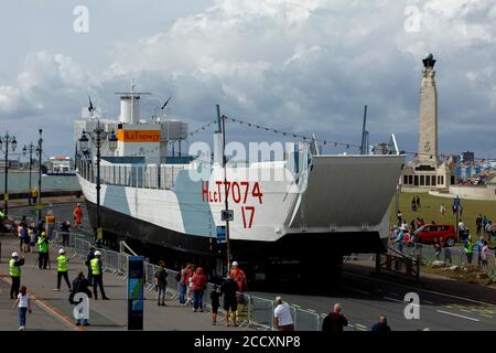 Portsmouth, Hampshire, Regno Unito. 24 agosto 2020. La gente guarda l'LCT 7074, l'ultimo carro armato anfibio sopravvissuto, si sposta verso il D-Day Museum di Portsmouth, lunedì 24 agosto 2020. L'imbarcazione che originariamente trasportava carri armati e soldati in Normandia, fu fatta galleggiare dalla chiatta del Museo Nazionale della Marina reale, dove era in fase di restauro, alla Promenade di Southsea, dove una gru costruì un ponte per la chiatta, Così potrebbe essere guidato alla sua nuova casa al D-Day Museum. Credit: Luke MacGregor/Alamy Live News Foto Stock