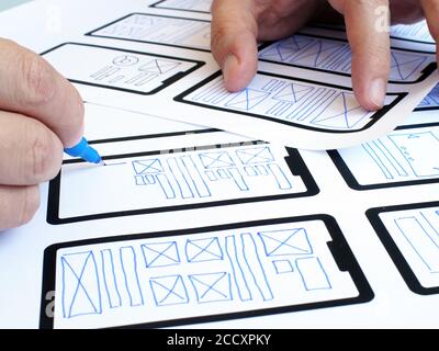 Il progettista UI UX sviluppa la progettazione di un'applicazione mobile. Foto Stock