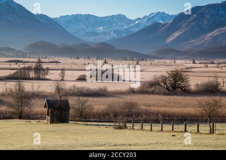 Vista sul muschio di Murnauer, di fronte alla capanna di legno, sul retro della catena Wetterstein, Murnau am Staffelsee, Baviera, Germania Foto Stock