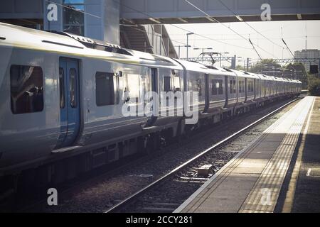 Piattaforma vuota, treno alla stazione ferroviaria di West Hampstead a Londra con luce solare Foto Stock