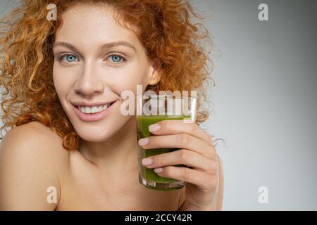 Giovane donna ben curata con una bevanda sana Foto Stock