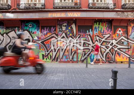 Fila di negozi con graffiti nel quartiere Malasana, Madrid, Spagna Foto Stock