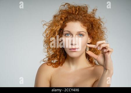 Donna che tiene una capsula in una mano Foto Stock