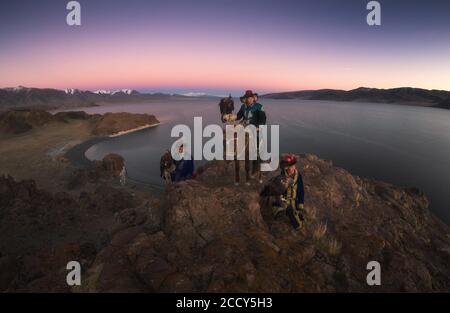 Cacciatori di aquile con le loro aquile addestrate nel lago di Tolbo. Provincia di Bayan-Ulgii, Mongolia Foto Stock