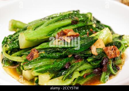 Un delizioso piatto cantonese, lattuga fritta con dace in salsa di fagioli neri Foto Stock